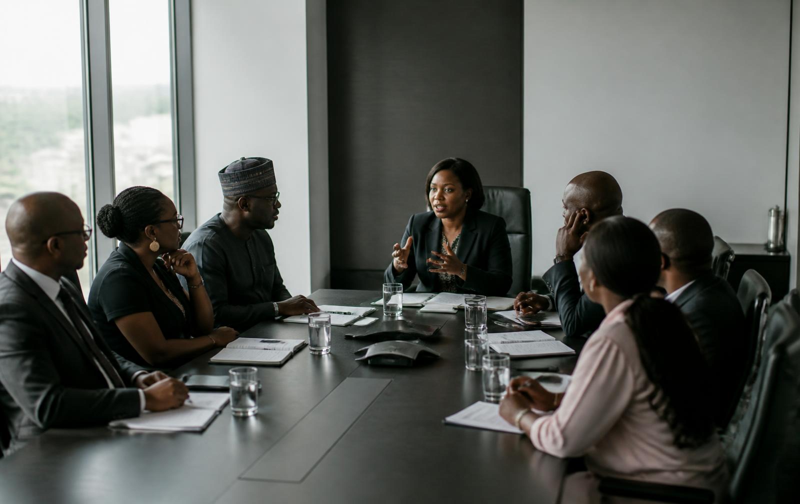 Executives in discussion around a boardroom table in a Nigerian office